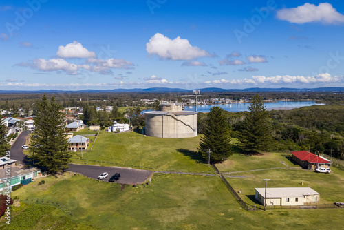 Fotografie Description: Aerial view of the concrete water tank beside the replica of Yamba’s original lighthouse on Pilot Hill, overlooking the coastal township in New South Wales, Australia