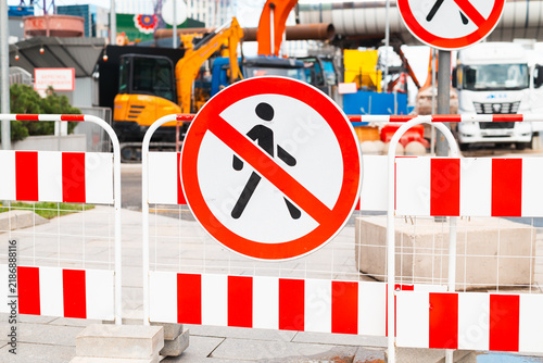фотографія A construction site is visible with barriers and no pedestrian signs in the foreground