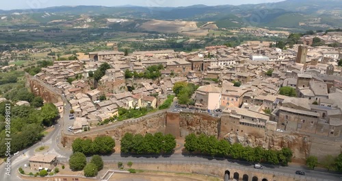 Aerial view of the edge of the town of Orvieto, in the province of Terni, in Umbria, Central Italy, with the road running below the vertical cliff of volcanic tuff and the hills of the countryside.