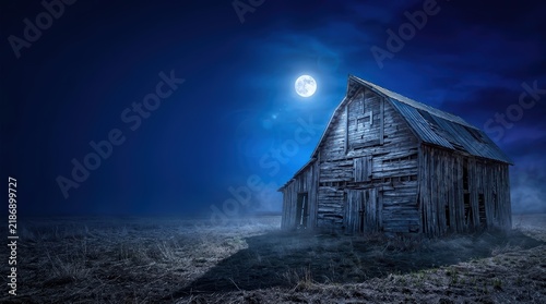 Abandoned Weathered Wooden Barn in a Dramatic Midnight Blue Rural Landscape under Full Moon with Large Copy Space for Advertising