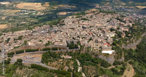 High angle view of the town of Orvieto, in the province of Terni, in Umbria, Central Italy, built on a plateau of volcanic tuff and surrounded by farmland, trees and the hills of the countryside.