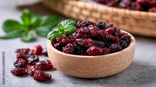 Dried cranberries in wooden bowl with fresh mint