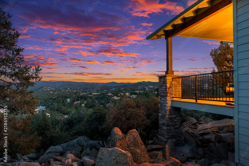 Obraz premium Sunset views over distant valley from balcony with stone railing pillar plus rocky ridges foreground