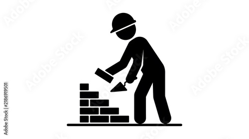 Construction worker building a brick wall with a trowel in a flat vector icon