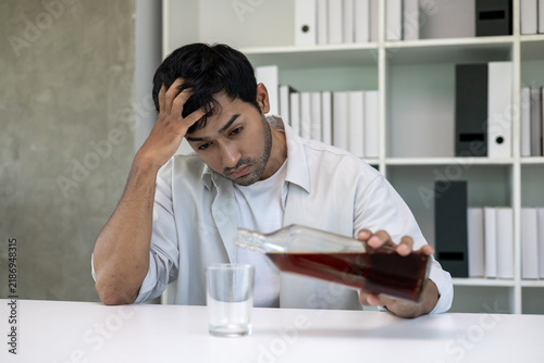 Bild auf Leinwand Depressed young Asian man addicted feeling bad drinking whiskey alone at home, s