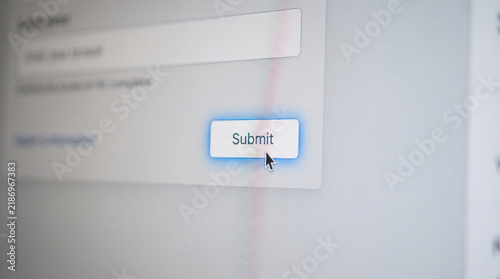 Computer mouse cursor clicking a submit button on a digital web form interface
