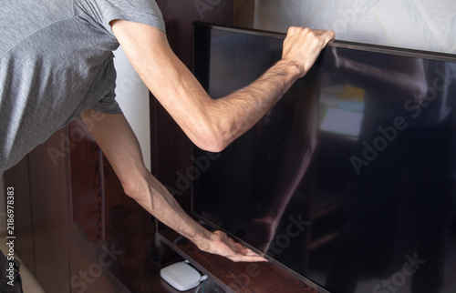 Bild auf Leinwand Man tries to save a TV during an earthquake.