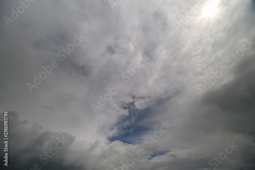 Konstfotografi Dramatic clouds dance across the sky, revealing glimpses of blue as daylight bre