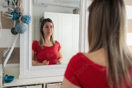 Quadro su tela Woman looking at herself in mirror reflecting introspection