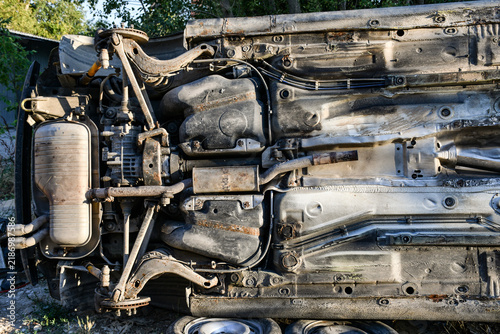 Obraz na płótnie Undercarriage of a vehicle resting on its side featuring the rear differential, exhaust muffler with dual tips, and rear suspension components