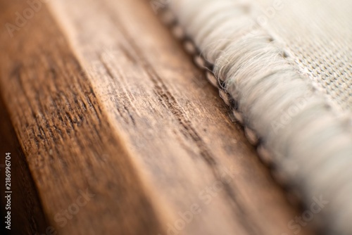 Natural oak wood plank edge meeting soft white fabric texture for interior design