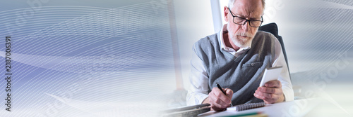 Senior businessman reading a message on his mobile phone, hard light; panoramic banner