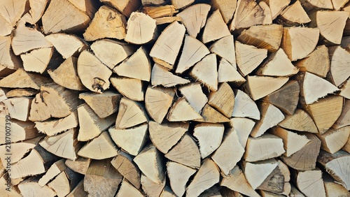 Close-up of neatly stacked split firewood showing natural wood grain and rustic texture, suitable as a background for heating, energy and sustainable living concepts.