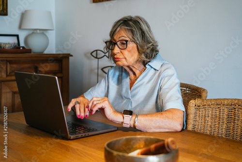 Senior woman using laptop for remote work at home
