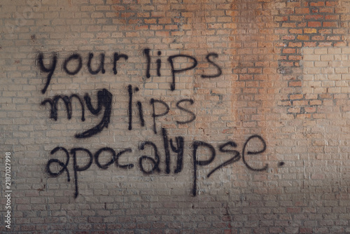 Writing on a red brick wall. Your lips, my lips, apocalypse. Background.