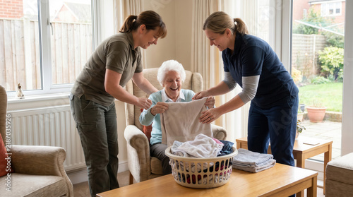 Caregivers folding laundry with elderly woman during long-term care