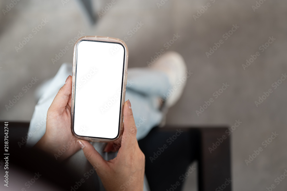 Fototapeta premium Overhead View Person Holding Smartphone With Empty White Display