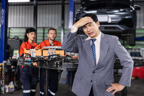 Fotografie Stressed Garage Manager Facing Repair Delays with Mechanics in Background