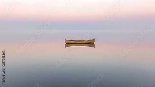 Empty wooden canoe on still lake at dawn, peaceful and untroubled scene