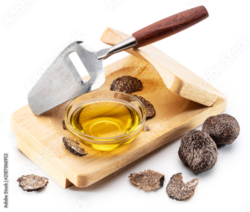 Quadro su tela Glass bowl of luxury black truffle oil with fresh truffle slices and wooden slicer board and slicer knife