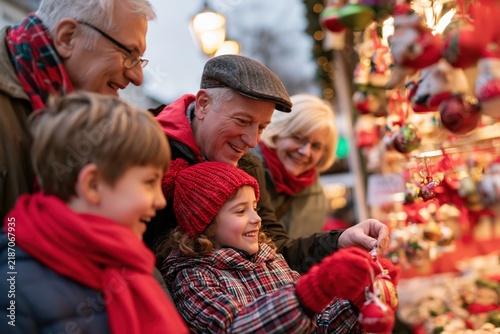 Grandparents and grandchildren selecting handmade Christmas ornaments outdoors