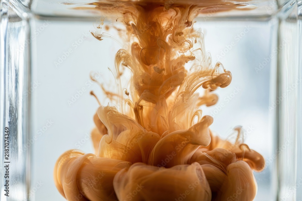 Obraz premium Brown ink swirls gracefully inside clear water forming abstract smoke-like shapes. Artistic backdrop for creative design, liquid motion, and conceptual presentations.