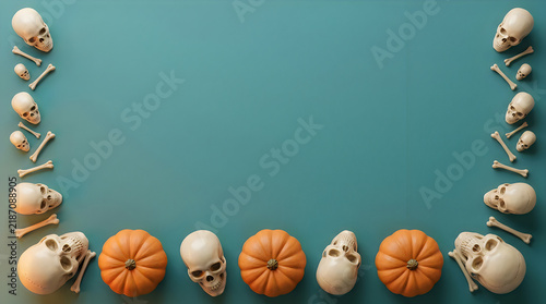 Halloween flat lay border with skulls and pumpkins, spooky autumn frame on teal background, festive holiday copy space