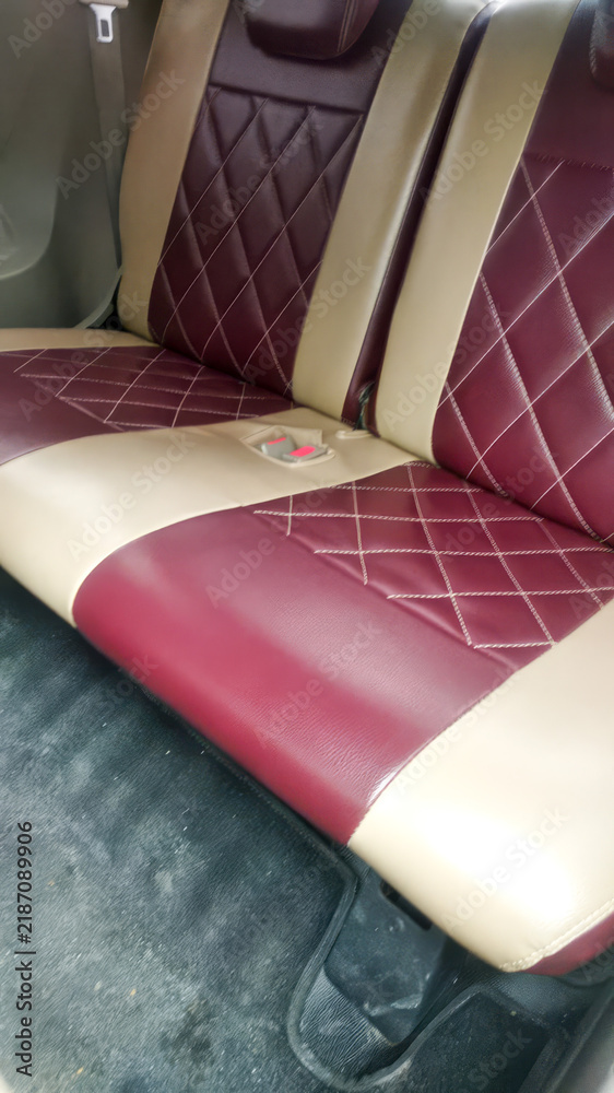 Obraz premium Custom car seat upholstery in a luxurious diamond stitch pattern, featuring a rich maroon and cream leatherette. This image highlights automotive interior design, craftsmanship.