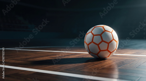 Fotografie Official textured futsal match ball resting on polished indoor parquet wooden sports arena court with white boundary lines in dramatic spotlight side illumination