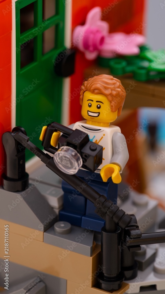 Obraz premium Tambov, Russian Federation - January 26, 2026 Close-up shot of a Lego man minifigure with camera standing on house porch outdoors