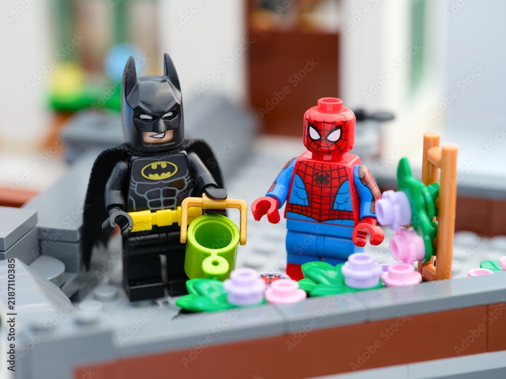 Obraz premium Tambov, Russian Federation - August 23, 2026 Lego Batman and Spider-Man minifigures gardening together on a rooftop terrace.
