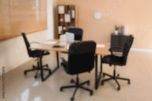 Фотография Corporate downsizing and office vacancy, empty chairs at a meeting table in a mo