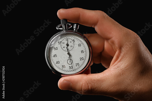 Foto Time management and deadline pressure, hand holding a vintage stopwatch to measu