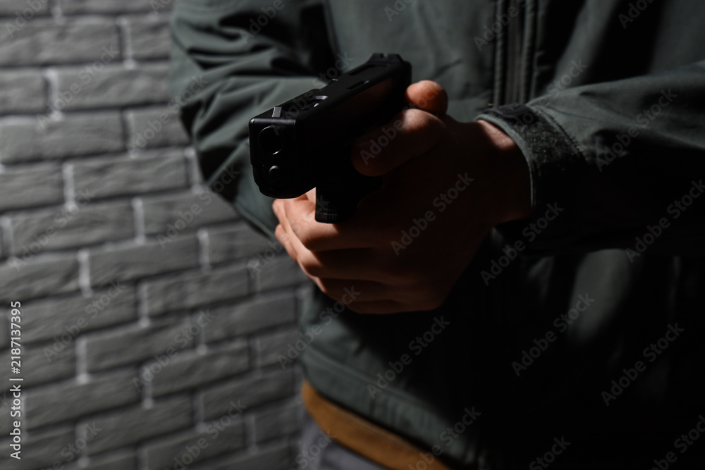 Obraz premium Crime and violence prevention, person holding a handgun in a dark urban environment for security threat or law enforcement training and safety