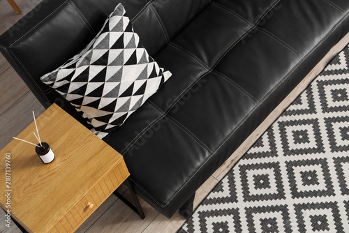 Obraz na plátně Interior design and home comfort, modern living room with black leather sofa and