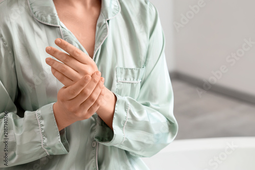 Foto Joint pain and arthritis symptoms, woman in pajamas massaging sore hand for reli