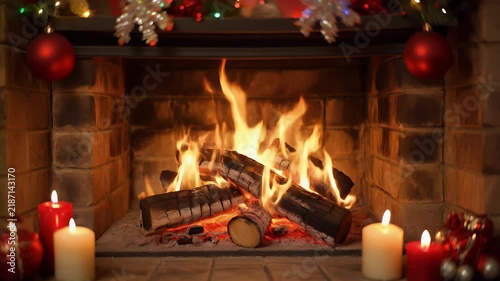 A warm and inviting fireplace crackles with burning logs, adorned with festive red ornaments and candles.