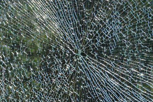 Obraz na płótnie Cracked shattered glass surface with radial fracture pattern and reflections