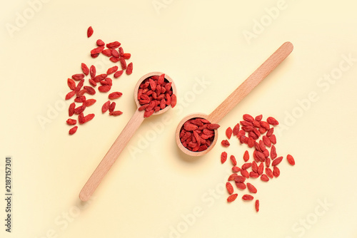 Obraz na plátně Wooden spoons with red dried goji berries on yellow background