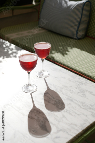Two Red Cocktails on Stone Table with Hard Shadows Outdoors