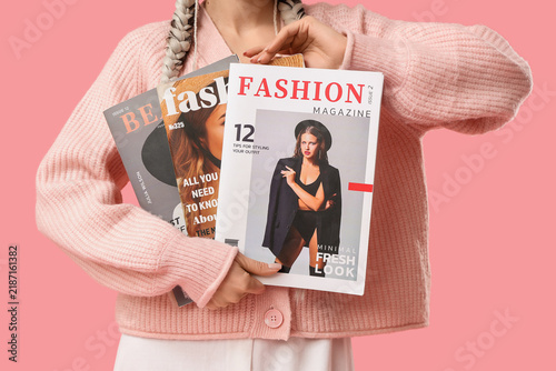 Beautiful young stylish woman with magazines on pink background, closeup