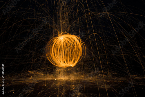 Fotografie Fire Spinning Light Painting Circle in the Dark Night