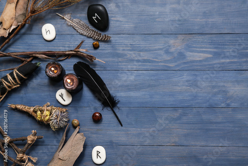 Konstfotografi Shamans accessories with runes and burning candles on blue wooden background