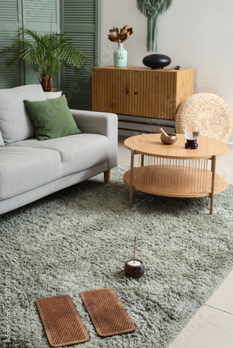 Sadhu board with aroma stick on carpet in living room interior