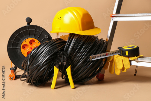 Konstfotografi Crimper, wires, hardhat and extension cable reel on beige background