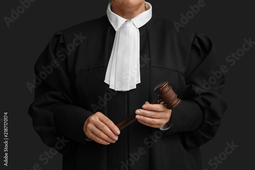 Fotografie Female judge with gavel on black background