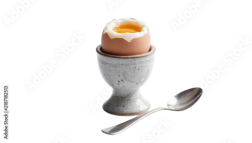 Soft boiled brown egg with runny yolk in speckled ceramic holder spoon, isolated on transparent background