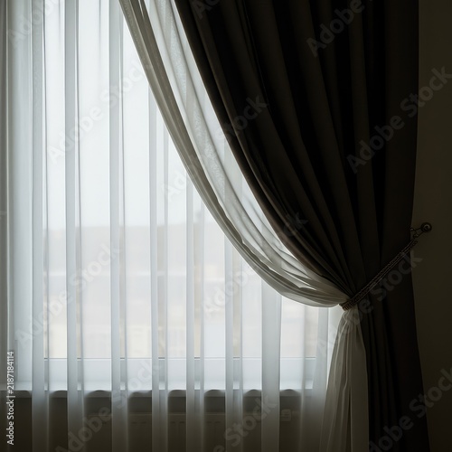 Elegant window treatment featuring heavy drapes and sheer panels, highlighting the renewed focus on detailed textile home decoration ,sheer ,atmosphere ,furnishing