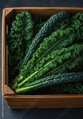 Freshly harvested curly kale leaves lying in a wooden crate or basket. Abundant superfood crop ready for healthy cooking ,curly ,cooking ,seasonal