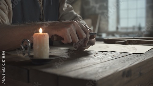 Foto Close up of medieval craftsman hands shaping a piece of wood with a small knife